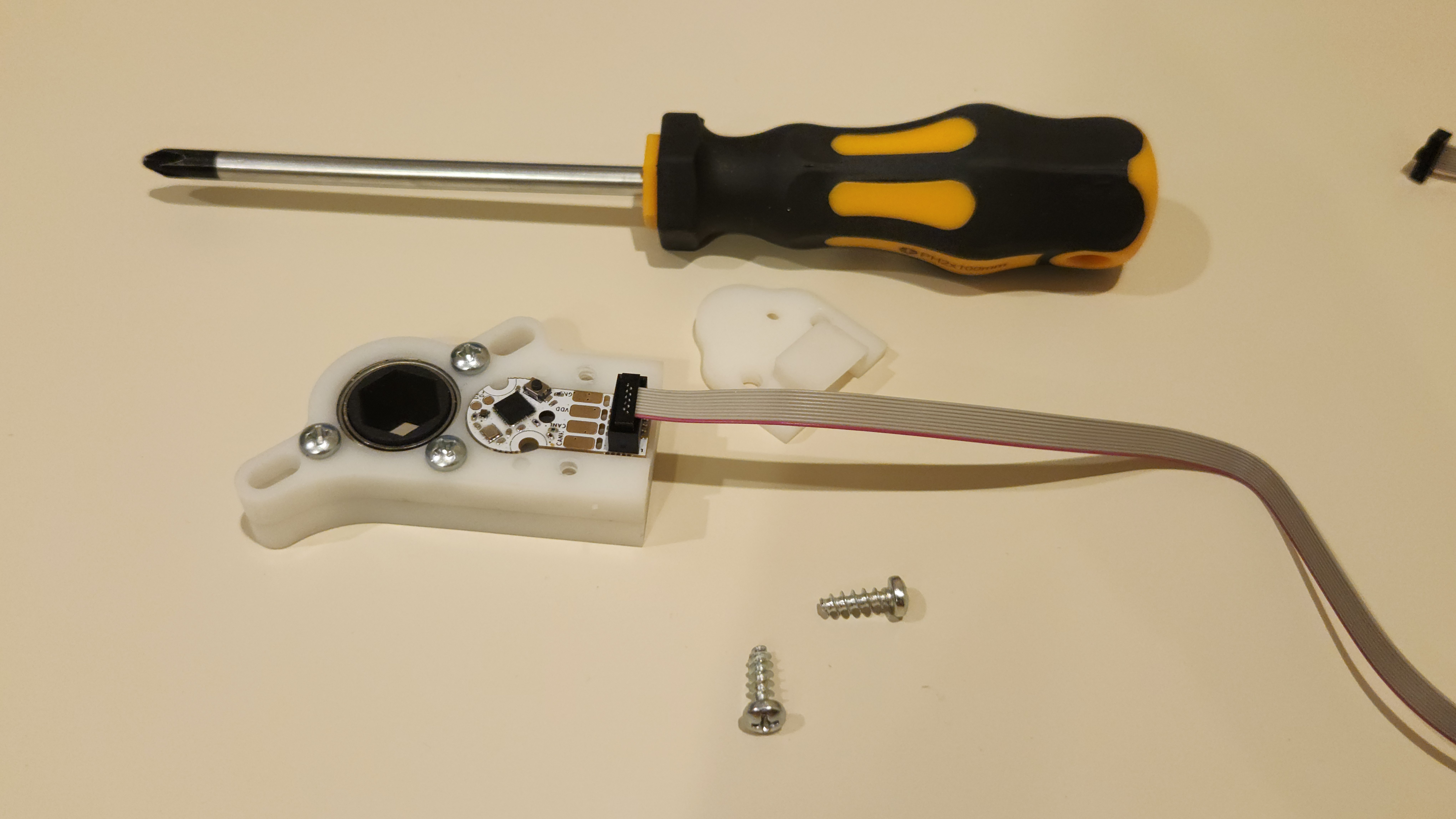 Image showing a Helium Encoder with a 10 pin IDC cable connected, placed in the throughbore package